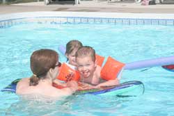 naturist mother and kids in the pool